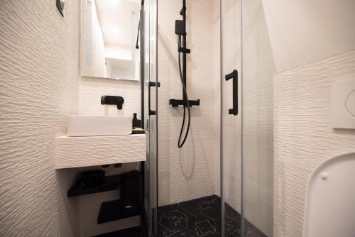 une salle de bain avec douche et lavabo dans l'établissement CIA - Studio du Moulin Rouge, à Paris