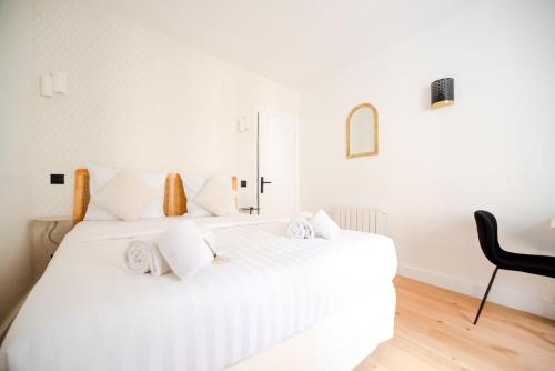 - un lit blanc avec des oreillers blancs dans l'établissement CIA - Studio du Moulin Rouge, à Paris