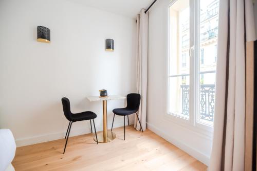 une table et deux chaises dans une pièce avec une fenêtre dans l'établissement CIA - Studio du Moulin Rouge, à Paris