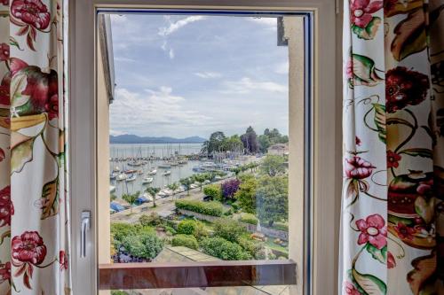 a window with a view of a harbor at Romantik Hotel Mont Blanc au Lac in Morges
