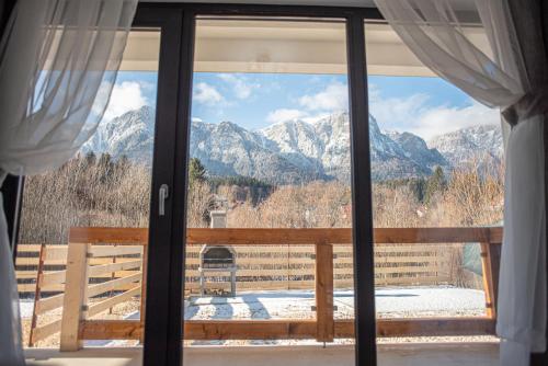 a window with a view of snow covered mountains at Yael Luxury Apartments 5 in Buşteni