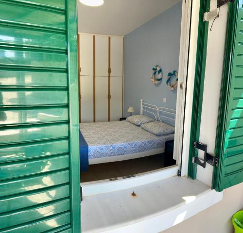 a bedroom with a bed in a room with a window at Andros Eco Home in Gavrion