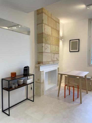 a dining room with a table and a fireplace at Studio ultra centre libourne - jacuzzi & vidéoprojecteur in Libourne