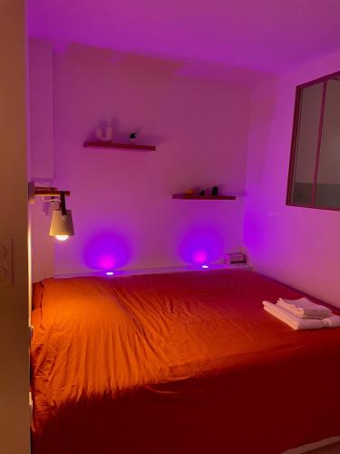 a bedroom with purple lights on a bed at Studio ultra centre libourne - jacuzzi & vidéoprojecteur in Libourne