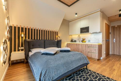 a bedroom with a bed and a kitchen at Aparthotel Tatrzański SPA in Białka Tatrzanska