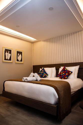 a bedroom with a large bed with colorful pillows at Zind Naaba Hotel in Lomé