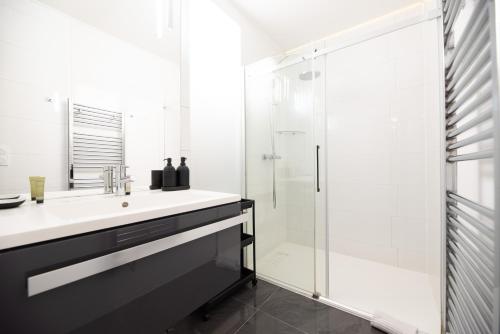 une salle de bain avec un lavabo et une douche dans l'établissement CIA - Parc Monceau 6P, à Paris