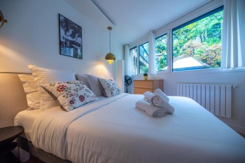 une chambre avec un lit blanc avec des serviettes dessus dans l'établissement CIA - Parc Monceau 6P, à Paris