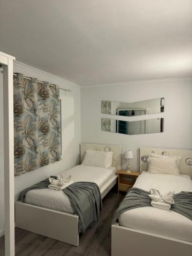 a bedroom with two beds and a mirror at Casa Estrelinha Vilamoura in Quarteira