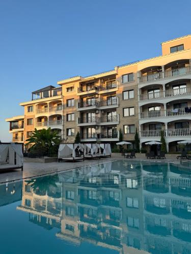 a building with a pool of water in front of it at South Beach Apartment at Valencia Gardens in Nesebar