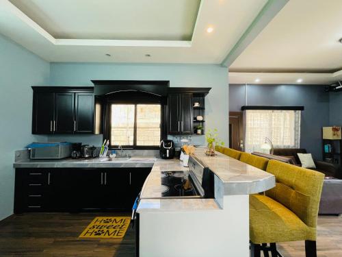 a kitchen with black cabinets and a yellow couch at Duplex en Residencial Los Llanos II etapa, Catacamas in Catacamas