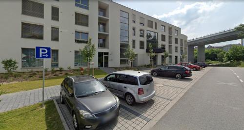 a group of cars parked in front of a building at ALURE RESIDENCES 9 & 24h self check-in, private parking in front of the apartment building included, new building, terrace, the apartment building has its own park with a lake and outdoor fitness, children's playground, CITY CENTER in Banská Bystrica