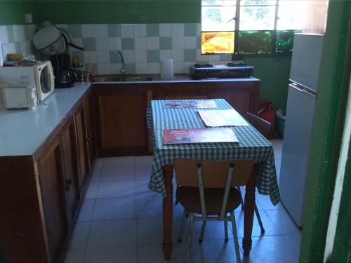 eine Küche mit einem Tisch mit 2 Stühlen und einem Kühlschrank in der Unterkunft Auberge Etiennette in Trou dʼ Eau Douce