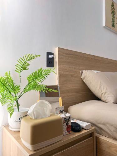 a bedroom with a bed and a plant on a table at Chip Homestay & Studio in Ho Chi Minh City
