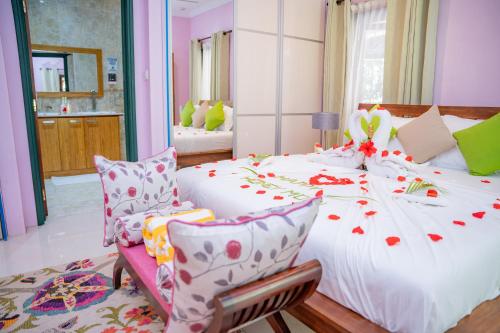 a bedroom with a large white bed and a chair at Pension Michel Villa Roche Bois in La Digue