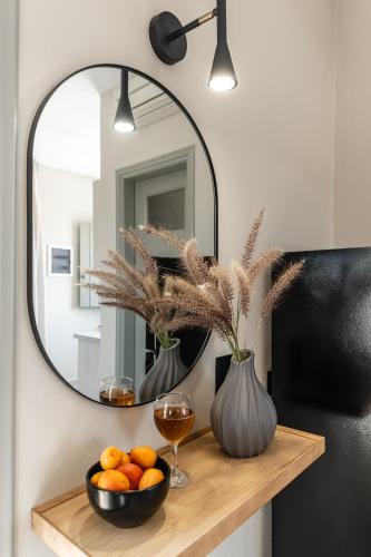 a table with a mirror and a bowl of oranges at Studios Kontos in Mikri Vigla