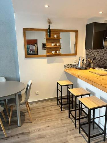 - une cuisine avec une table, des chaises et un comptoir dans l'établissement Charmante maison Drômoise, à Pierrelatte