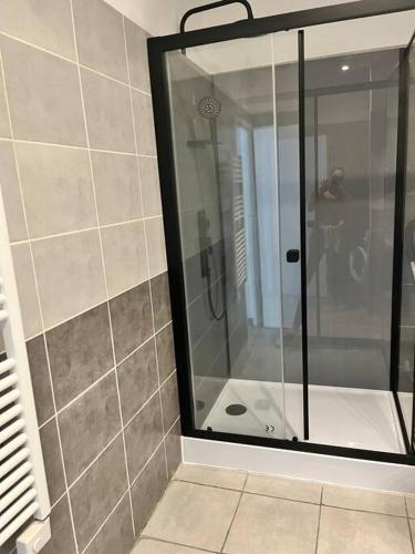 une douche avec une porte vitrée dans une salle de bain dans l'établissement Charmante maison Drômoise, à Pierrelatte