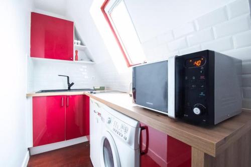 - une cuisine équipée d'un four micro-ondes et d'un lave-linge sur un comptoir dans l'établissement CIA - Avenue Hoche Studio, à Paris