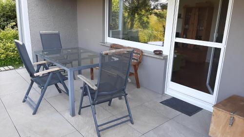 a glass table and chairs sitting on a porch at glüxnest in Bernstadt