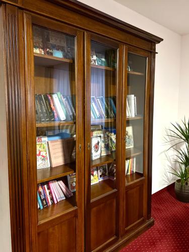 a wooden book cabinet filled with lots of books at Hotel Sebastian u Hoffera in Modra