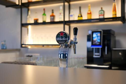 a bar with a counter with a drink dispenser at Hotel Kiel by MELIO in Kiel
