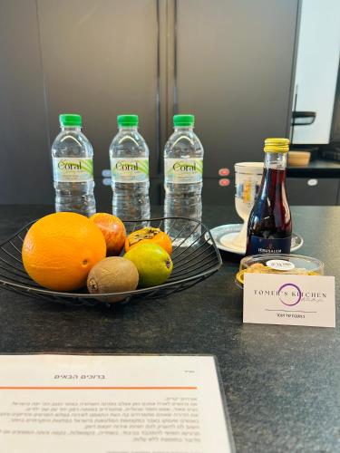 a plate of fruit and bottles of water on a counter at הפנינה השחורה in Mitzpe Ramon