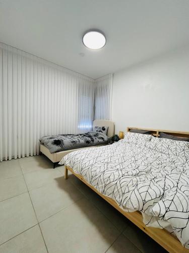 a bedroom with a bed and a chair in it at הפנינה השחורה in Mitzpe Ramon