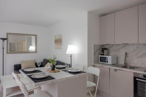 une cuisine avec une table avec des chaises et un micro-ondes dans l'établissement Le Cosy Place - charmant T2 avec Parking - Orléans Hyper Centre, à Orléans
