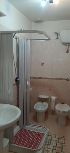 a bathroom with two toilets and a shower and a sink at Il Campanile Civico 35 in Aieta