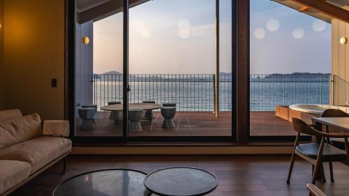 a living room with a couch and a large window at GARDENIA Sunset in Takamatsu