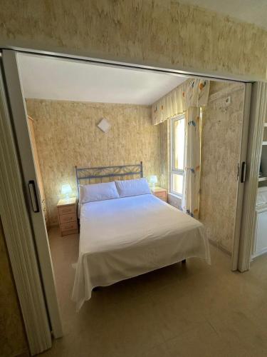 a bedroom with a bed and a window at Apartamento BuenasVistas in Algarrobo-Costa