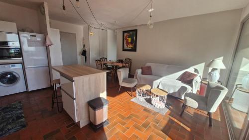 une cuisine et un salon avec un canapé et une table dans l'établissement Le Poseidon Grande terrasse vue port a 100m plage, à Saint Cyprien Plage