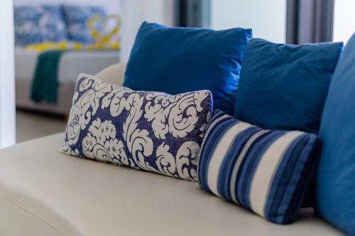 a couch with blue and white pillows on it at Modern Apartment near the Beach in Pointe aux Cannoniers