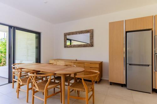 a kitchen with a table and chairs and a refrigerator at Modern Apartment near the Beach in Pointe aux Cannoniers