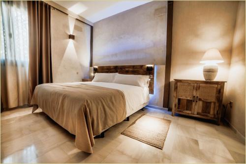 Un dormitorio con una cama y una lámpara sobre una mesa. en LA POSADA DEL LIMONERO, en Fuentes de Andalucía