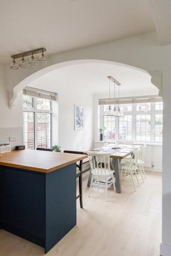 a kitchen and dining room with a table and chairs at Bright & Modern 4 br House 100 metres from Beach in West Wittering