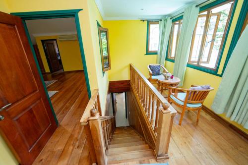 a room with a staircase and a table and chairs at Pension Michel Villa Roche Bois in La Digue
