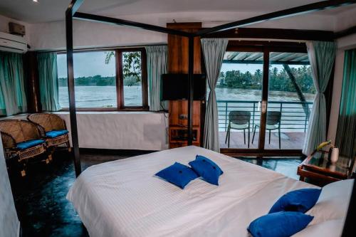 a bedroom with a bed with blue pillows on it at Kadal boutique beach stay in Green Island