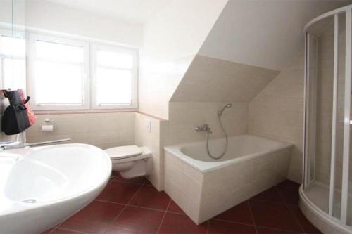 a bathroom with a white tub and a toilet and a sink at Hanne-Hus in Kühlungsborn