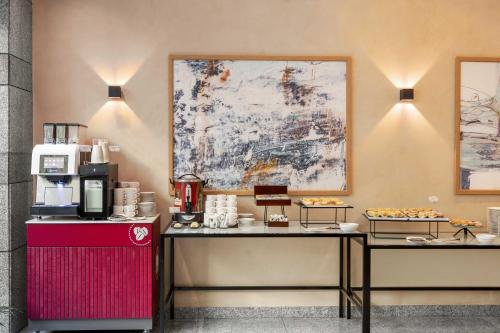 a coffee shop with two tables and a refrigerator at Wyndham Wroclaw Old Town in Wrocław