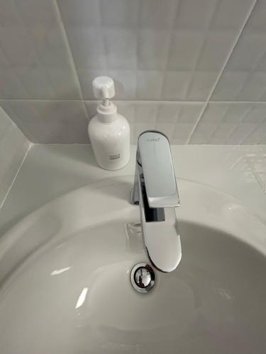 a soap dispenser sitting on top of a white sink at Zen Harmony House Udonthani in Udon Thani