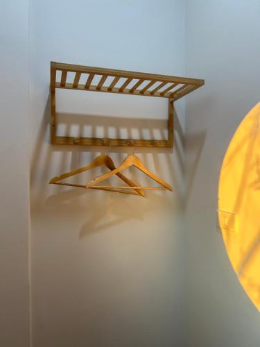 a shelf with two hangers on a wall at Zen Harmony House Udonthani in Udon Thani