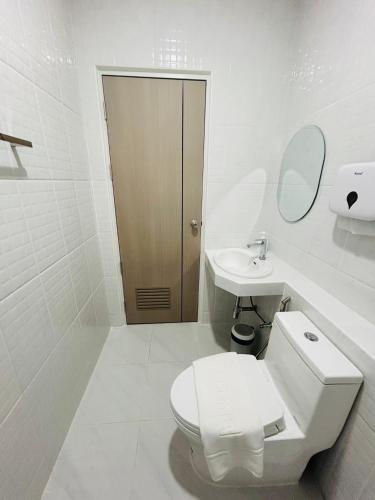 a white bathroom with a toilet and a sink at Zen Harmony House Udonthani in Udon Thani