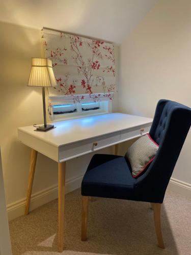 a desk and a chair with a lamp and a lamp at 9 White Cottage in Eastdean