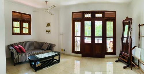 a living room with a couch and a table at Sagarika Beach Hotel in Moragalla