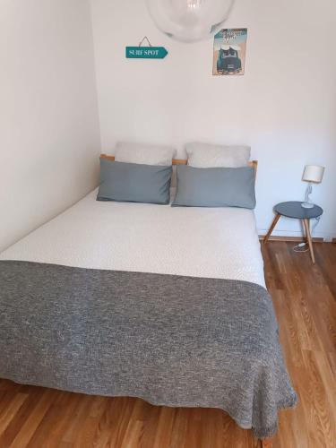 - un lit avec des oreillers bleus dans une chambre dans l'établissement 2 pièces Petit Bayonne, à Bayonne