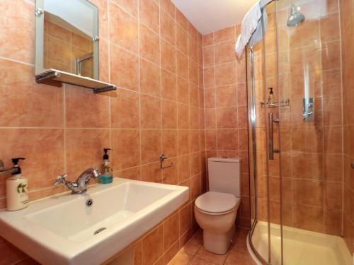 a bathroom with a sink and a toilet and a shower at Suite 3 in Stroud