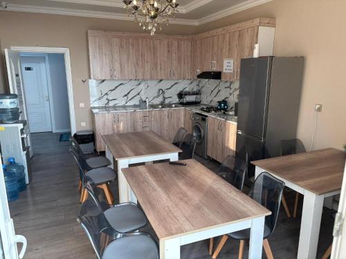 a kitchen with wooden tables and chairs and a refrigerator at Premium Sea View Hotel & Hostel in Baku