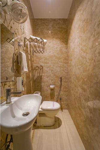 a bathroom with a white sink and a toilet at Shiv Rudraksh Resort, Near Assi Ghat in Varanasi